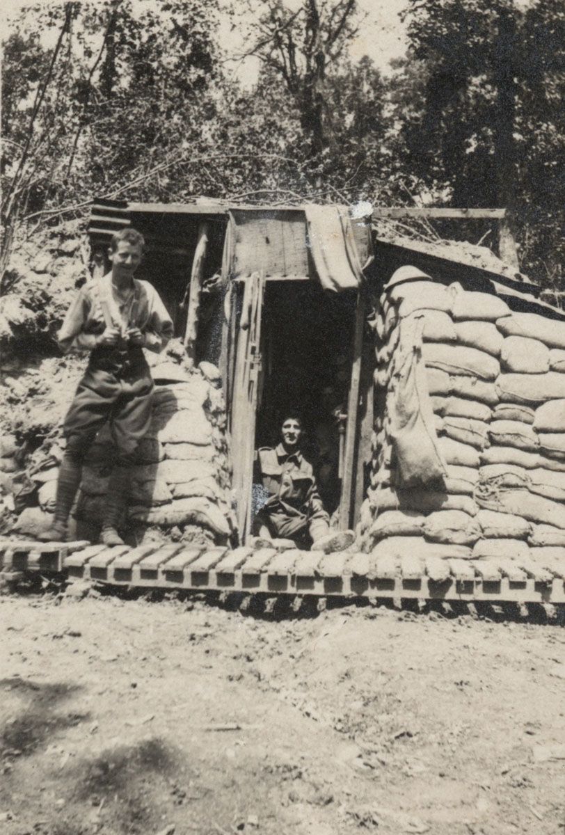 Two soldiers pose for the camera outside their sandbagged dugout in the rear area of Ploegsteert, Belgium.